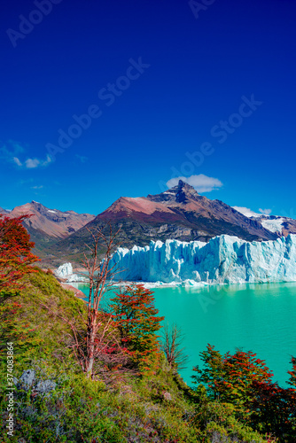 Famous Perito Moreno glacier and mountain turquoise lagoon with austral forests at golden Autumn in Patagonia, South America, Argentina