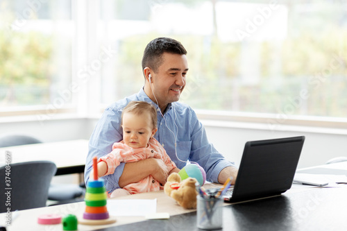 remote job, multi-tasking and family concept - middle-aged father in earphones with baby working at home office