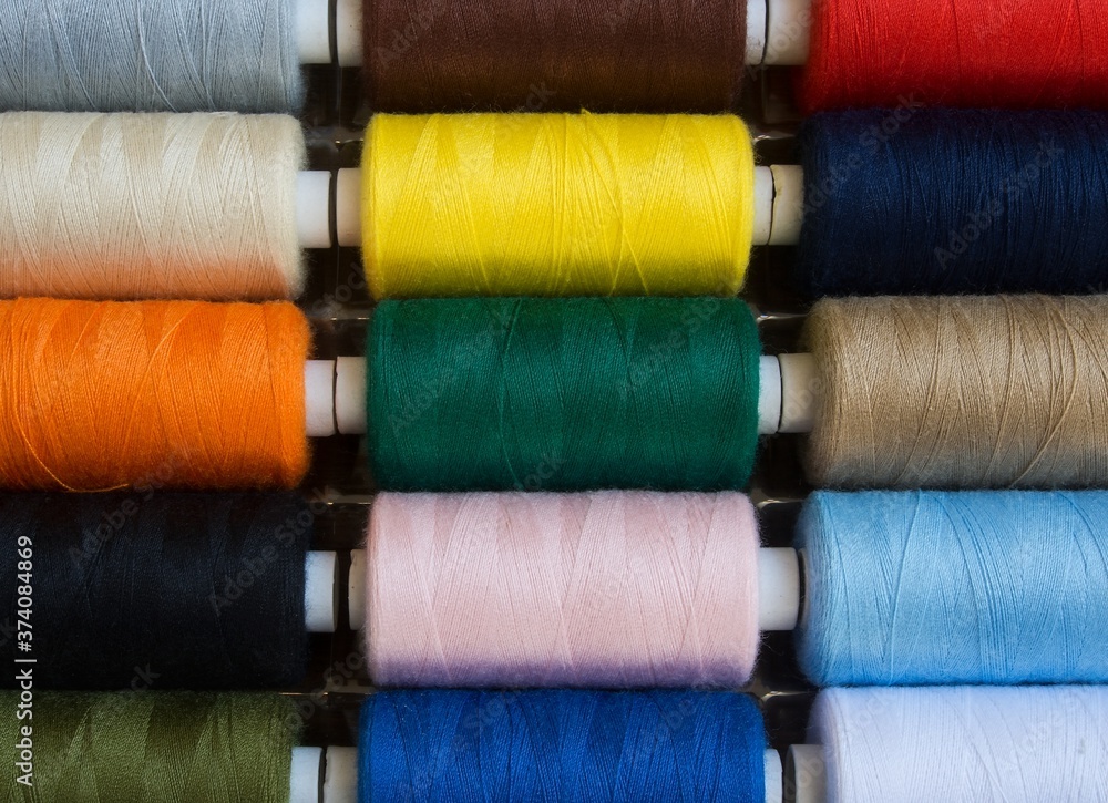 Threads of different colors on spools, regularly arranged in rows, 2 Threads of different colors on spools, regularly arranged in rows, 2