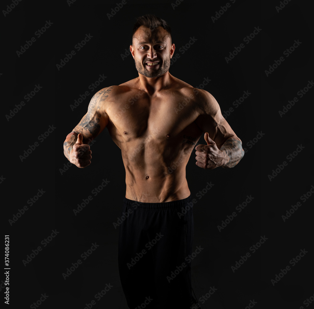 Handsome bodybuilder man with an ideal body, after coaching abdominal muscles, biceps, triceps on dark background. Handsome bodybuilder man with an ideal body, after coaching abdominal muscles, biceps, triceps on dark background.