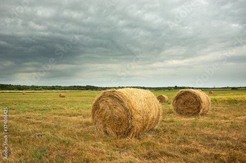 Hay in the field and dark clouds in the sky