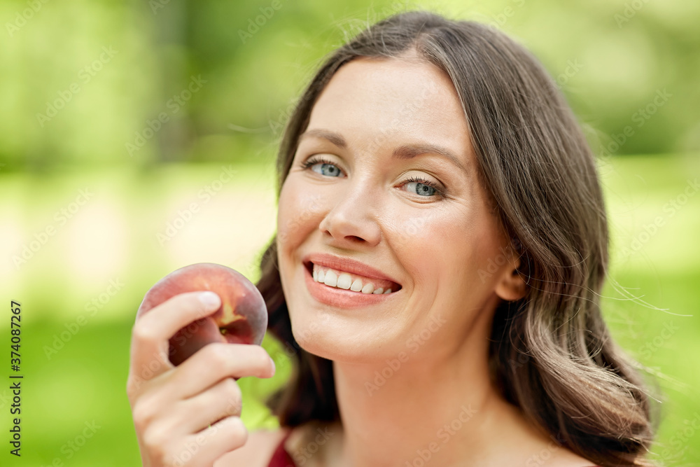 healthy eating and people concept - portrait of happy woman with peach at summer park healthy eating and people concept - portrait of happy woman with peach at summer park