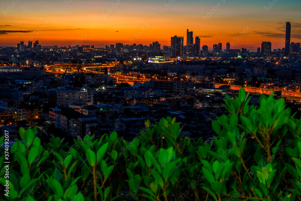 The high angle background of the city view with the secret light of the evening, blurring of night lights, showing the distribution of condominiums, dense homes in the capital community