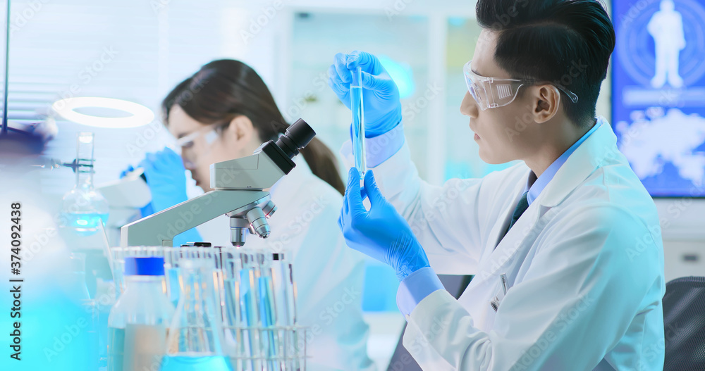 Asian scientist use microscope Asian scientist use microscope