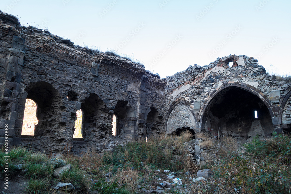 Ruins of nameless Russian orthodox church, Kars, Turkey. Remains abandoned, there's no roof. Building has three walls left. Inner courtyard is grown over by wild grass. Located near famous Kars Castle