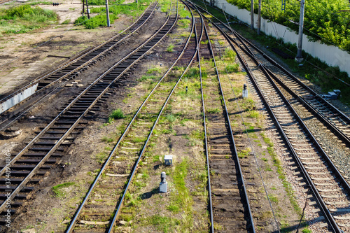 Railroad tracks going into perspective and converging in one direction. The landscape of the railway station around