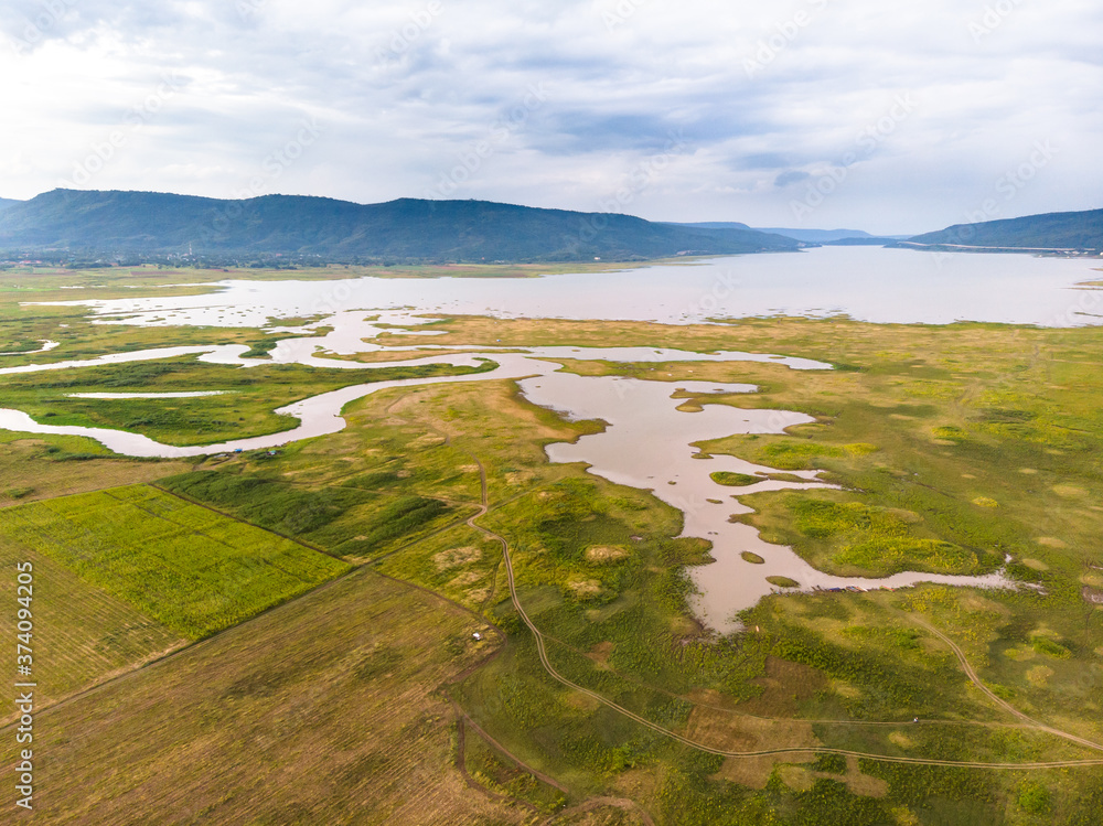Scenic landscape aerial view of field river and basin against a natural mountain, Drone shot tropical landscape with noise and grain processed Scenic landscape aerial view of field river and basin against a natural mountain, Drone shot tropical landscape with noise and grain processed