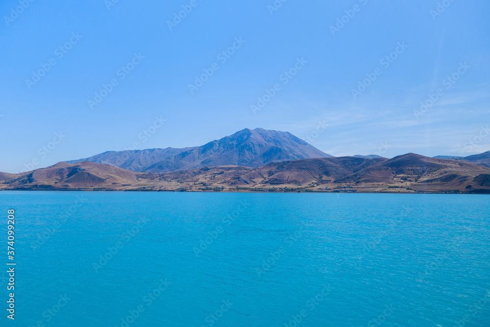 Panoramic view onto volcano Mount Artos (or Çadır in Turkish) & coastline from Akdamar Island, Van Lake, near Gevaş, Turkey. Bright blue colour of water created by soda elements in its consist