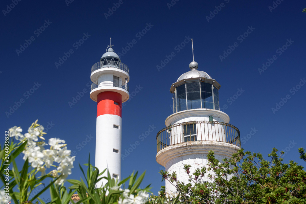 Two lighthouses together on the Spanish coast. The ancient and the modern together. Sunny day in El Rompido, Huelva, Andalusia, Spain Two lighthouses together on the Spanish coast. The ancient and the modern together. Sunny day in El Rompido, Huelva, Andalusia, Spain