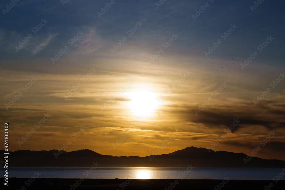 Panoramic view onto golden sunset above waters of Van Lake. Silhouettes of mountains are on background. Picture taken from top of famous Van Rock (with cognominal ancient fortress), Van, Turkey.