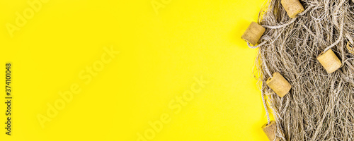 Old fishing net on yellow background. Space for text or design