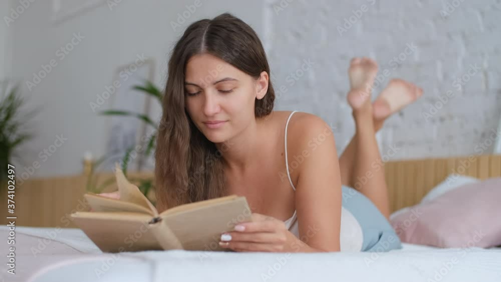 Leisure at home, Stay in the house, Beautiful woman, home weekend. Woman lying on bed at home and reading a book Leisure at home, Stay in the house, Beautiful woman, home weekend. Woman lying on bed at home and reading a book