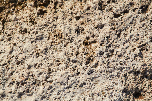 Terrain gravel wall. Rocky hill. Light beige abstract textured background. Surface. Cracked rock stones. Copy space