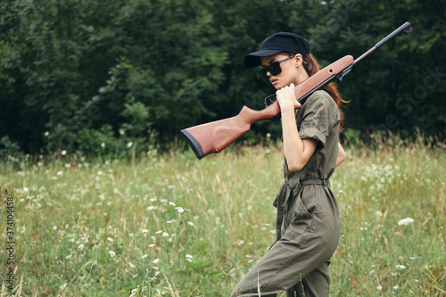 Woman on outdoor In sunglasses with a gun hunting travel 