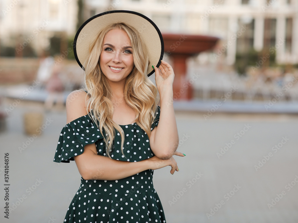 Beautiful smiling woman in dress with hat at park outdoor
