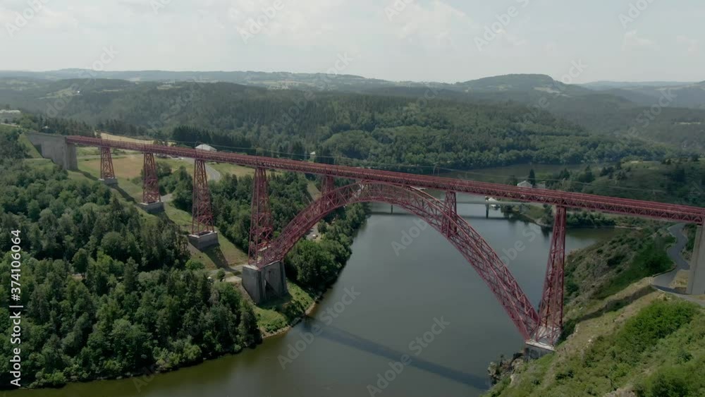 Aerial panorama shooting of the Viaduc de Garabit in France. Beautiful red railway bridge over the river between the hills Aerial panorama shooting of the Viaduc de Garabit in France. Beautiful red railway bridge over the river between the hills