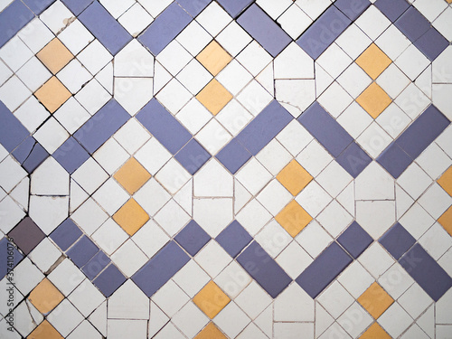 Real antique wall tiles background texture. White, blue and yellow geometric pattern.