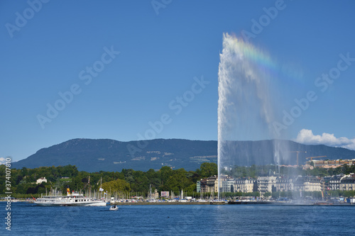 the water jet fountain and an old steam boat on lake Geneva, switzerland