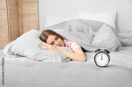 Young woman with alarm cloc...