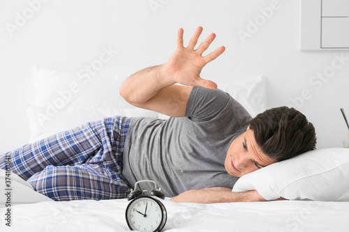 Young man with alarm clock ...