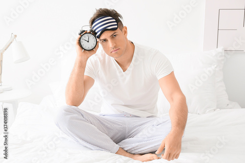 Young man with alarm clock ...