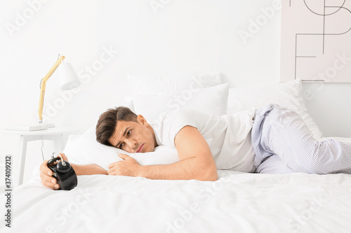 Young man with alarm clock ...