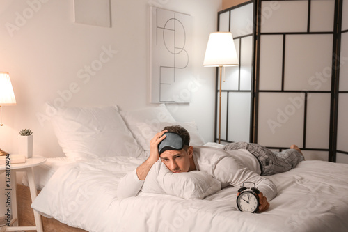 Young man with alarm clock ...