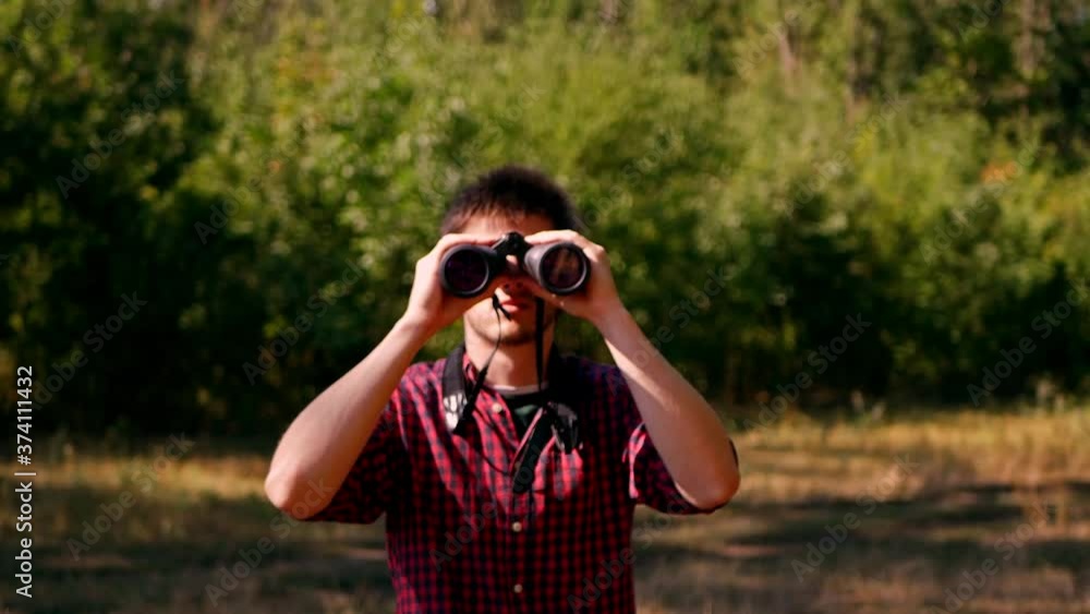 Man looking through binocular at the forest. Bird watching. Nature explore. Hiking tourist. Man looking through binocular at the forest. Bird watching. Nature explore. Hiking tourist.