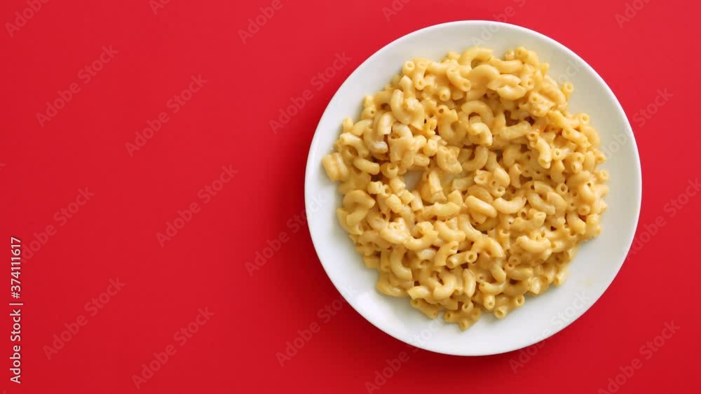 Eating Macaroni and Cheese on a Red Background Eating Macaroni and Cheese on a Red Background