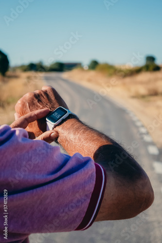 An old man on the street wearing a smart watch photo