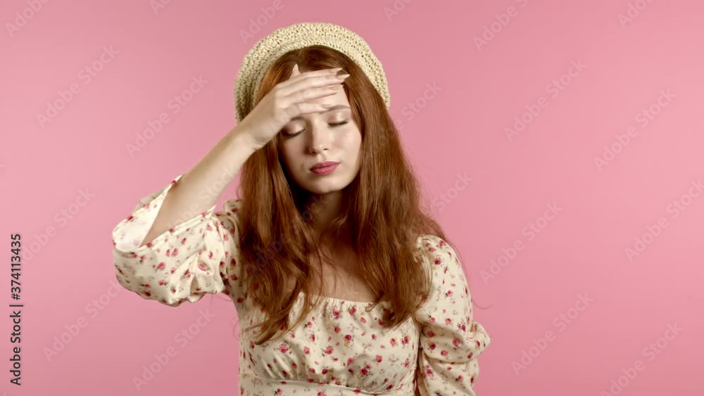 Young tired woman is dissatisfied, unhappy. PInk studio portrait of girl, she exhales from heat or stuffiness, waves arms at herself Young tired woman is dissatisfied, unhappy. PInk studio portrait of girl, she exhales from heat or stuffiness, waves arms at herself