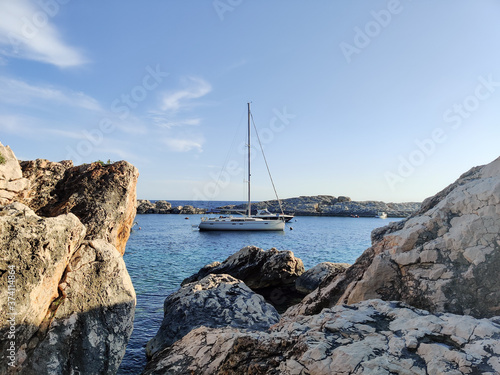 Sailboat mooring in a small cove of beach Velo Zarace on Hvar island, Croatia in sunset. photo