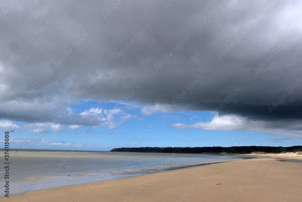 Plage Dragey-Ronthon à marée basse sous un ciel nuageux