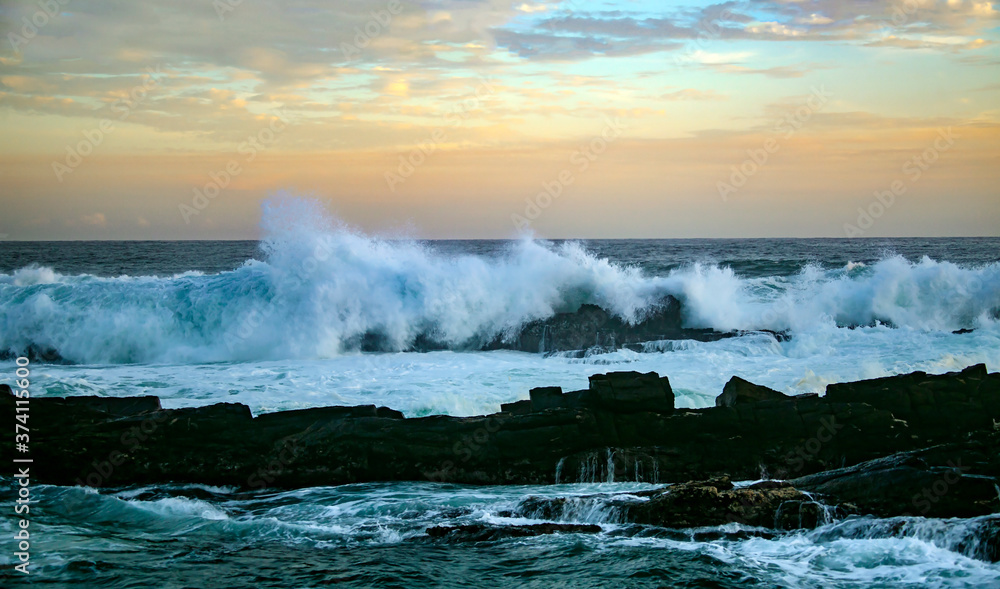 Obraz premium Sunset and storm waves on the ocean coast.