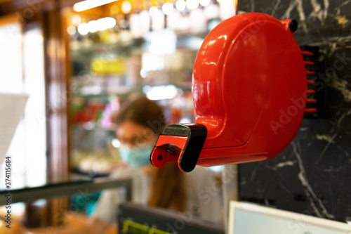 Red ticket dispenser from a bakery. Ticket dispenser concept. photo