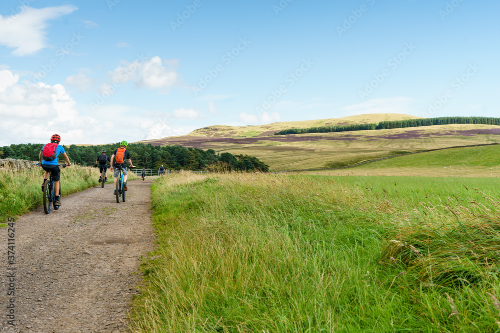 Few cyclist cycling in nature. Mountain bike outdoor trail in scottish highlands