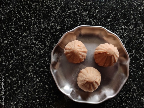 Modak on plate black background, famous sweet in India