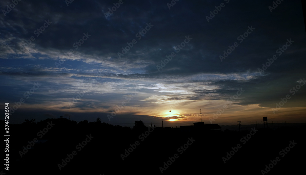 Sunset sky background with clouds and sun, photo image wallpaper.