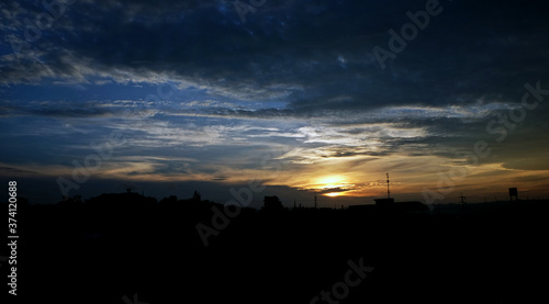 Sunset sky background with clouds and sun, photo image wallpaper.
