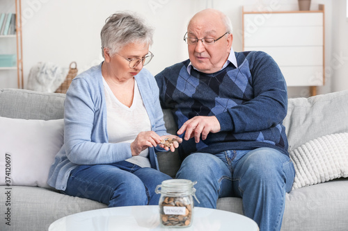 Senior couple counting mone...