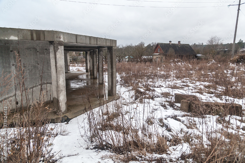 Unfinished concrete house on the banks of a frozen river Unfinished concrete house on the banks of a frozen river