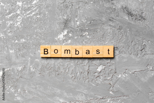 bombast word written on wood block. bombast text on cement table for your desing, concept