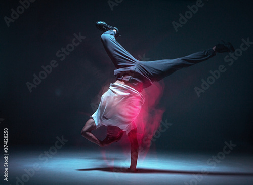 Photos Cool young guy breakdancer dancing hip-hop in neon light
