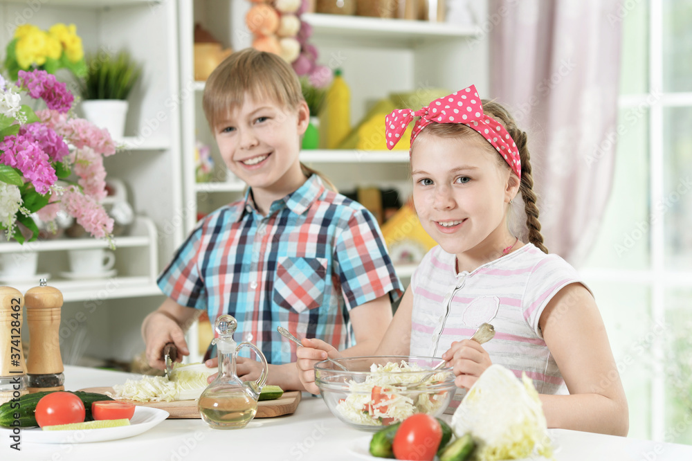 Cute brother and sister cooking together in kitchen