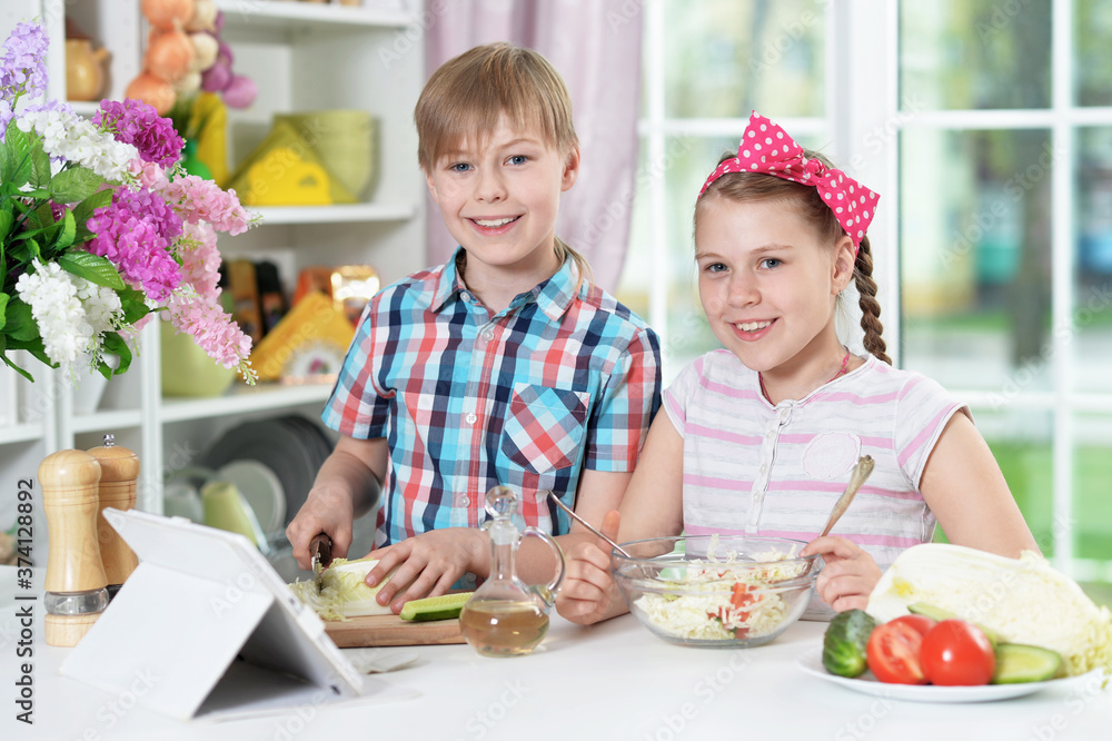 Cute brother and sister cooking together in kitchen Cute brother and sister cooking together in kitchen