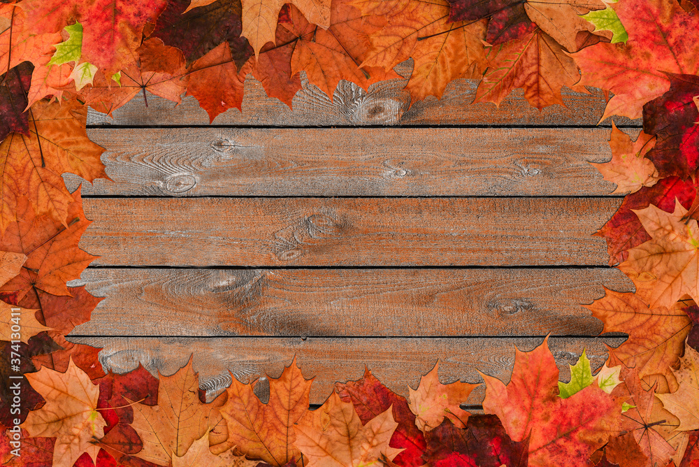 Autumn leaves background. Maple dry leaves on a wooden background with a copy of the space. Old surface with leaves. Change of seasons. Autumn composition Autumn leaves background. Maple dry leaves on a wooden background with a copy of the space. Old surface with leaves. Change of seasons. Autumn composition