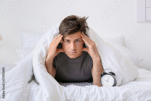 Young man with alarm clock ...