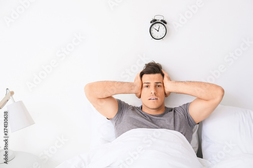 Young man with alarm clock ...