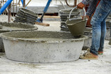 Builders, stone, sand, cement and water are mixed together in a mixer.
