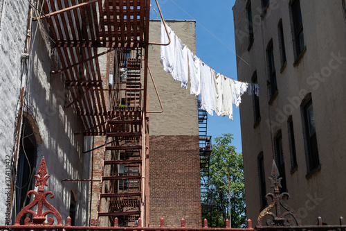 Urban Outdoor Clothes Line with White Clothes and Fire Escapes on New York City Apartment Buildings © James